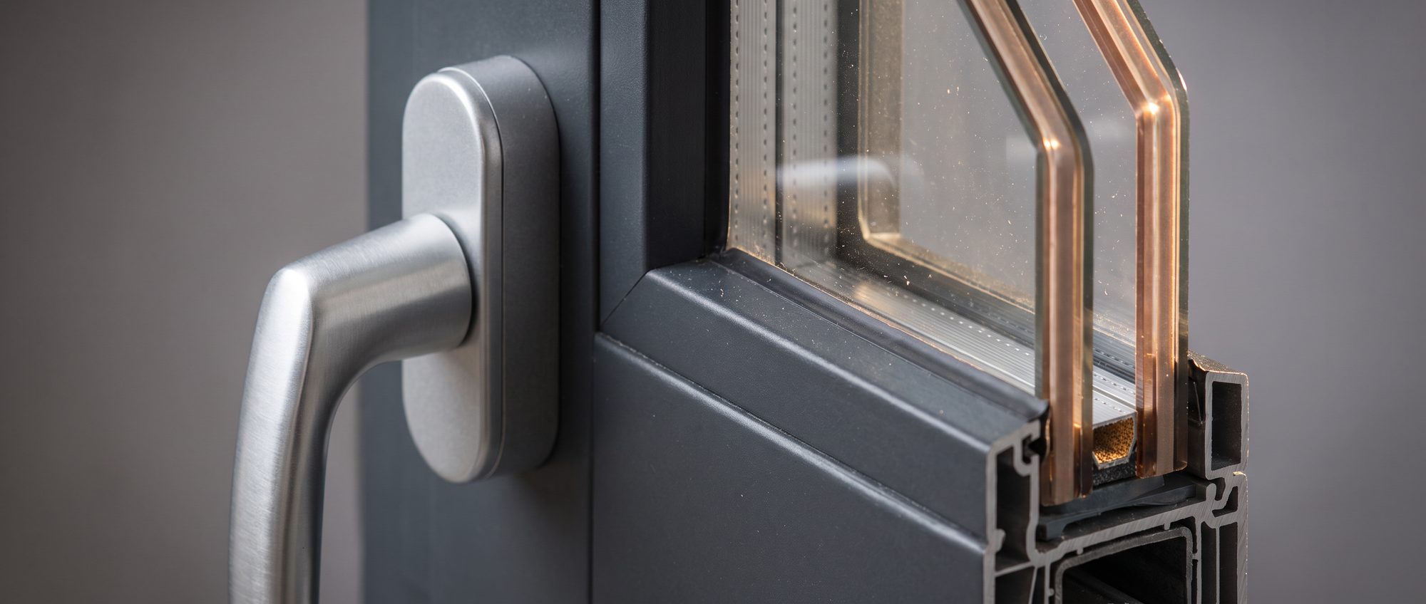 Makroaufnahme moderner Fenstertechnik: Beschlag, Glasleiste und 3-fach-Glaskante